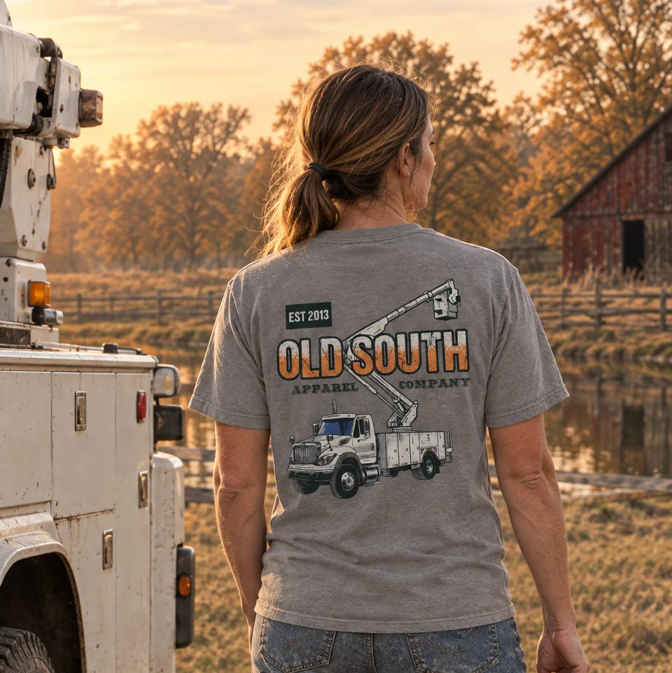 Old South Apparel Lineman Truck short sleeve tee in Graphite featuring a front pocket logo and hand-drawn lineman utility truck graphic on the back.