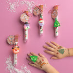 Mud Pie Jolly Tattoos and Light-Up Ring Set featuring gold foil Christmas temporary tattoos in a corked tube with a festive light-up character ring.