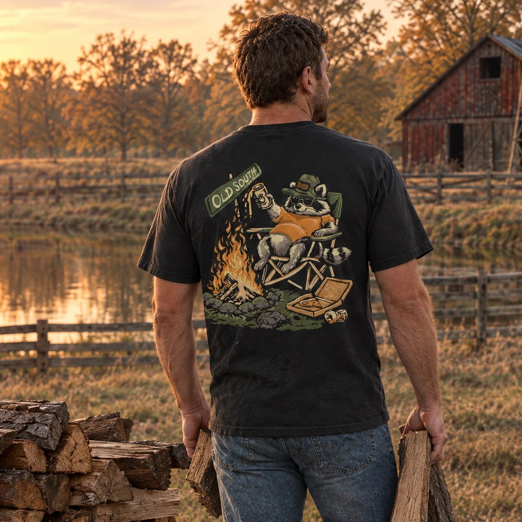 Old South Apparel Campfire Bandit short sleeve pocket tee in Black featuring a playful outdoor-inspired raccoon graphic.