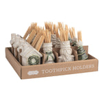 A cardboard tray labeled 'TOOTHPICK HOLDERS' holding multiple ceramic toothpick holders in off-white and green glazes, each filled with wooden toothpicks, on a white background.
