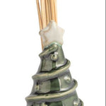 Four small ceramic toothpick holders shaped like a house with a green wreath, a snowman, a Santa figure, and a Christmas tree, arranged in a row on a white background.