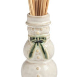 Four small ceramic toothpick holders shaped like a house with a green wreath, a snowman, a Santa figure, and a Christmas tree, arranged in a row on a white background.