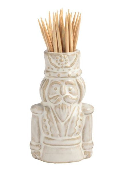 Four small ceramic toothpick holders shaped like a house with a green wreath, a snowman, a Santa figure, and a Christmas tree, arranged in a row on a white background.