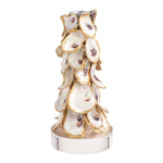 A decorative sculptural vase or candle holder made from overlapping oyster shells with gold-toned edges and a polished silver base, shown on a plain white background.