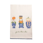 An off-white kitchen tea towel with a scalloped blue border, featuring a blue and orange autumn-themed illustration of three vases with pumpkins and the cursive text 'give thanks' near the bottom.