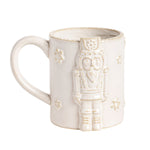 An off-white ceramic mug featuring a raised nutcracker figure on the front and small embossed star details, set against a plain white background.