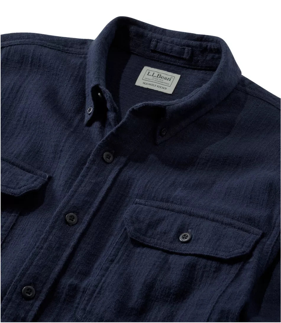 Close-up of a dark navy blue textured button-down shirt by LLBean, showing the collar label, front buttons, and chest pockets.