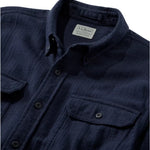 Close-up of a dark navy blue textured button-down shirt by LLBean, showing the collar label, front buttons, and chest pockets.