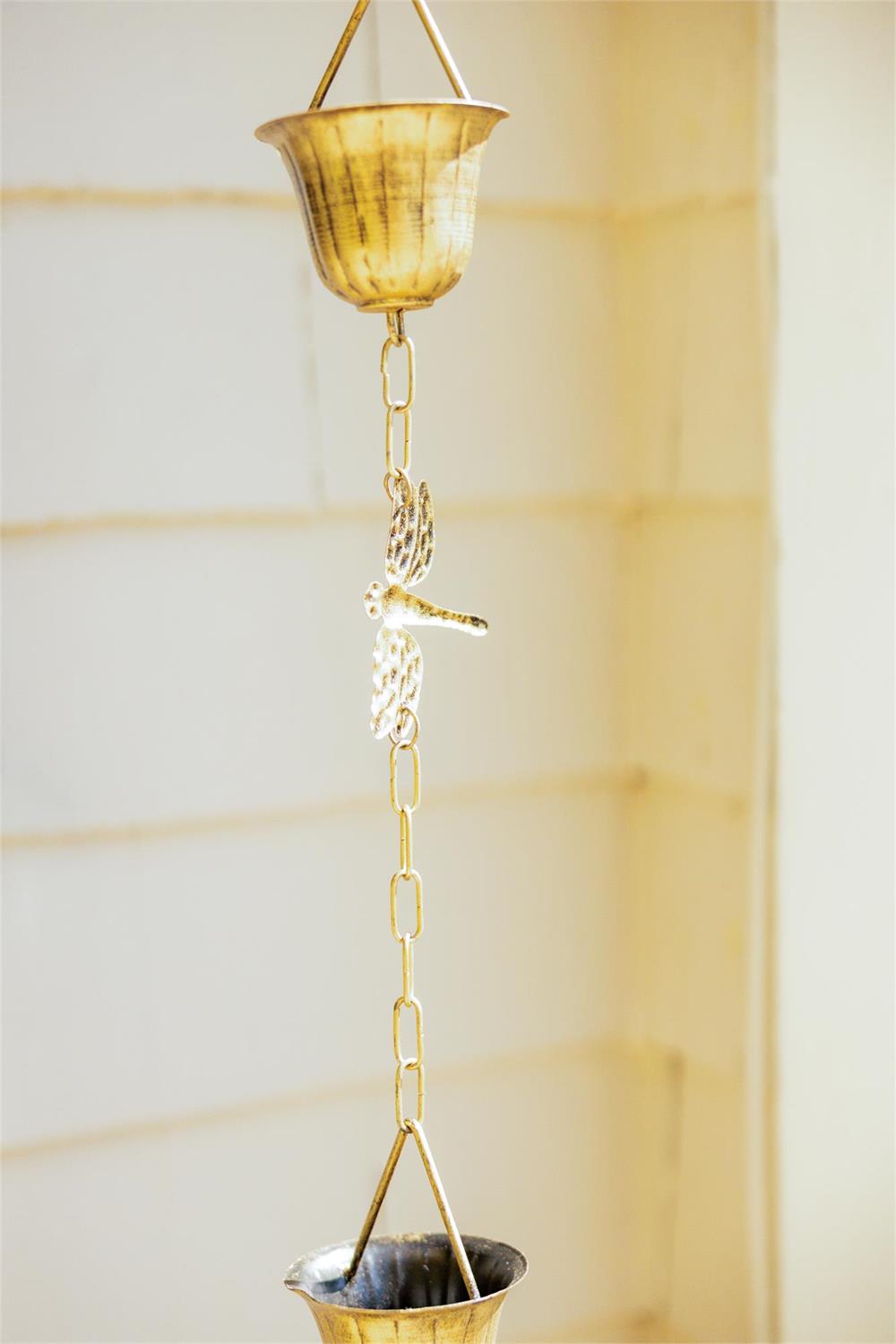 Eight-foot golden iron rain chain featuring decorative dragonflies, designed to guide rainwater while adding an elegant accent to porches and gardens.