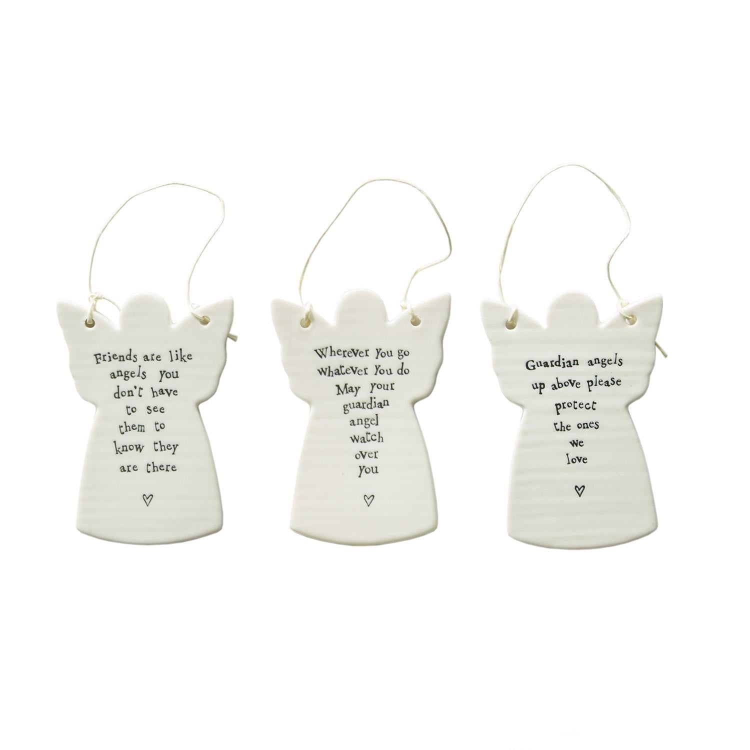 Three white ceramic angel ornaments with engraved text on a white background