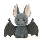 JellyCat Broox Bat plush featuring soft charcoal-grey fur, oversized ears, textured bat wings, and a sweet embroidered face, perfect for Halloween and fall.