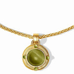 A gold pendant necklace featuring a round bezel-set olive green cat's eye stone, accented with four small green gemstones on a white background.