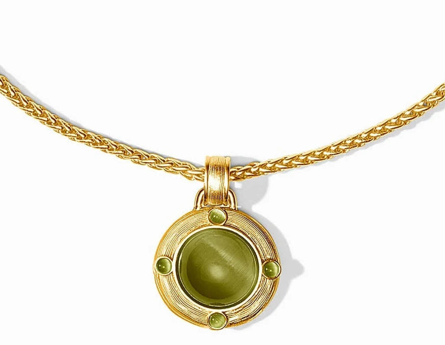 A gold pendant necklace featuring a round bezel-set olive green cat's eye stone, accented with four small green gemstones on a white background.