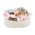 Woven basket filled with baby items including teddy bears, socks, and plush toys on a white background