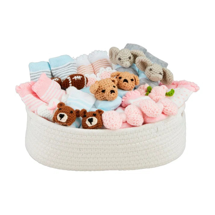 Woven basket filled with baby items including teddy bears, socks, and plush toys on a white background