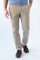 A person wearing beige straight-leg chinos with a blue t-shirt and brown leather shoes, shown from the waist down against a white studio background.