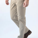Person wearing beige pants and brown shoes on a white background