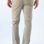 A person shown from the back wearing light beige chino pants, a blue shirt, and dark brown shoes against a plain white studio background.