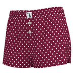 A pair of women's shorts in burgundy with a white polka dot pattern, featuring a button-fly front and a small white brand label on the waistband.