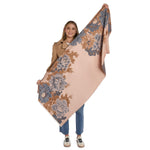 Person holding a large floral-patterned blanket with a plain background