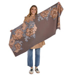Person holding a large floral-patterned brown fabric