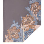 Floral patterned rug with brown and blue colors on a gray background