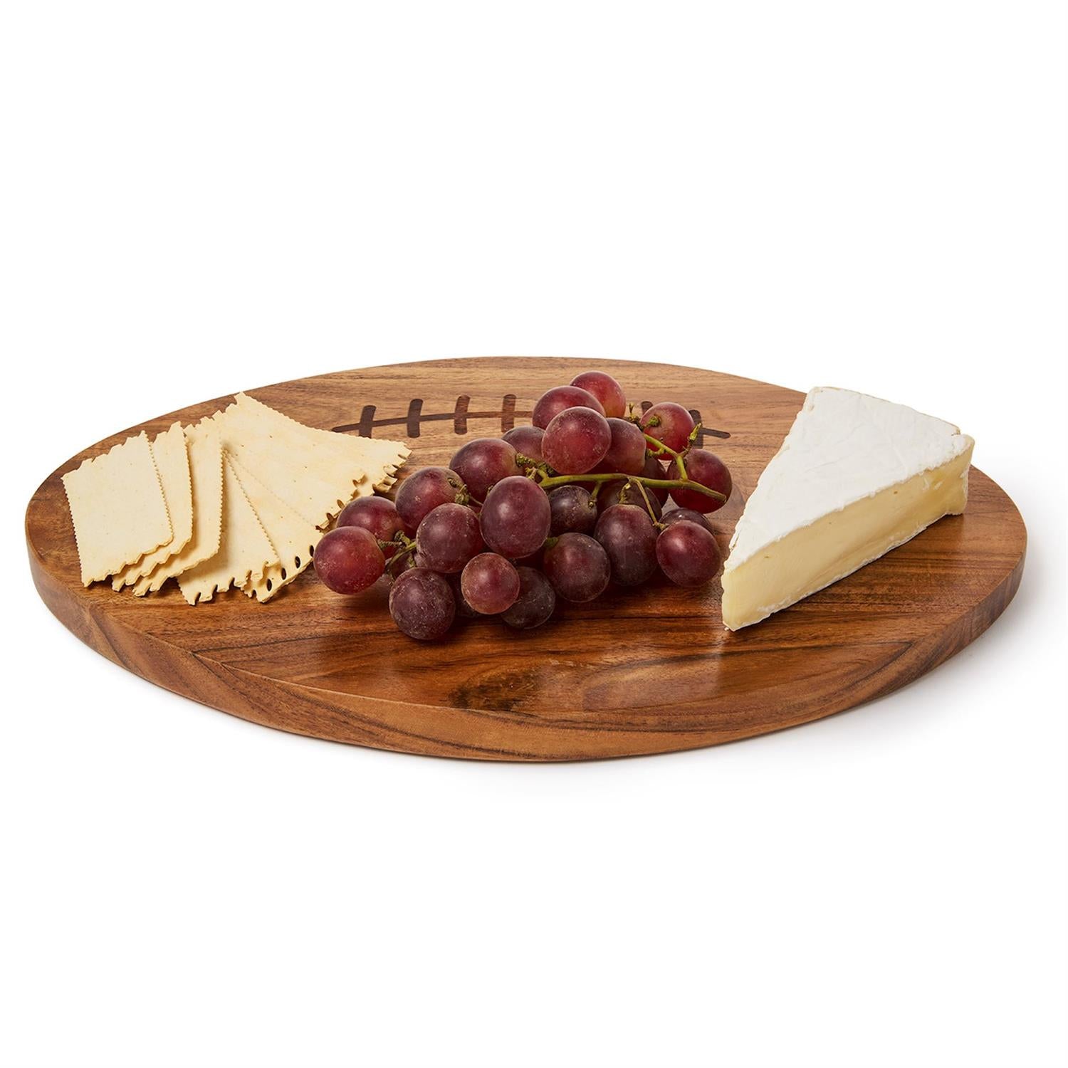 An oval wooden serving board with a football-inspired design, styled with crackers, a wedge of brie cheese, and a bunch of red grapes on a white background.