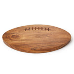 An oval wooden serving board shaped like a football, featuring a dark brown engraved lacing detail on the top surface, shown on a clean white background.