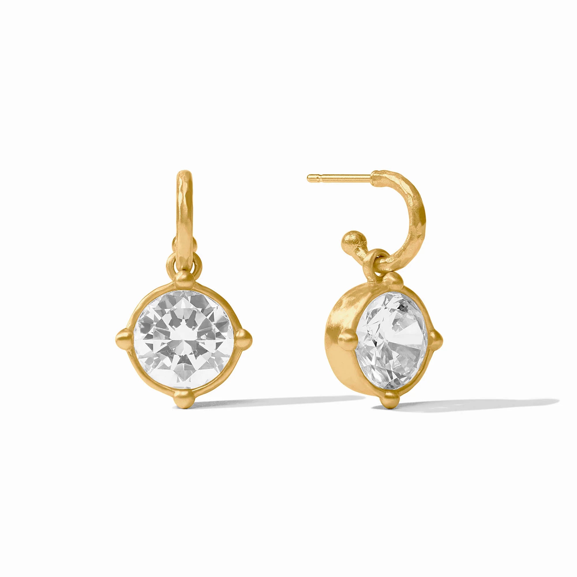 Gold earrings with clear gemstones on a white background