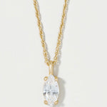 A gold necklace with a marquise-cut clear gemstone pendant, shown against a plain light background.