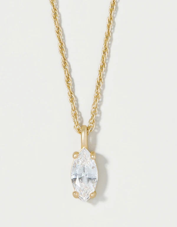 A gold necklace with a marquise-cut clear gemstone pendant, shown against a plain light background.