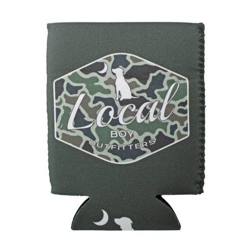 A dark gray neoprene can cooler sleeve featuring a central hexagonal patch with a green and black camouflage pattern, a white dog silhouette, and the text 'Local Boy Outfitters'. The sleeve has a stitched edge and a matching dark gray bottom tab with white moon and dog graphics.