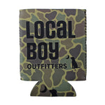 A beverage can cooler sleeve with a green, brown, and beige camouflage pattern, featuring the text 'LOCAL BOY OUTFITTERS' and a black silhouette of a dog looking up at a moon.