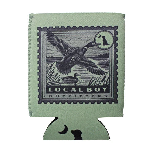 A sage green can cooler featuring a vintage-style duck stamp design with a goose, a duck, and the text 'LOCAL BOY OUTFITTERS'. The bottom tab of the can cooler has a black dog silhouette and a crescent moon, set against a plain white background.
