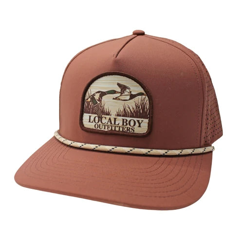 A terracotta brown trucker hat with a front patch reading 'LOCAL BOY OUTFITTERS' and a braided rope detail around the brim, shown on a plain white background.