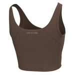 A brown racerback sports bra with the text 'LOCAL GIRL' printed in white on the chest, shown against a plain white background.