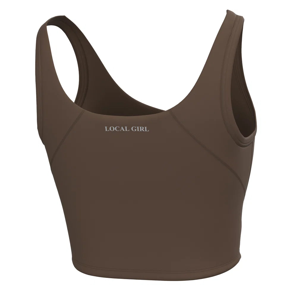 A brown racerback sports bra with the text 'LOCAL GIRL' printed in white on the chest, shown against a plain white background.