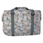A rectangular duffel bag with a muted camouflage pattern in gray, beige, and brown, featuring two vertical gray webbing straps with black plastic buckles and a top carry handle.