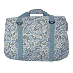 A rectangular duffel bag with a blue, green, and gray camouflage pattern, featuring two vertical blue webbing straps with black plastic buckles and a top carry handle, shown against a plain white background.