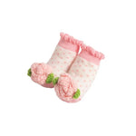 Pair of pink baby socks with white polka dots on a white background