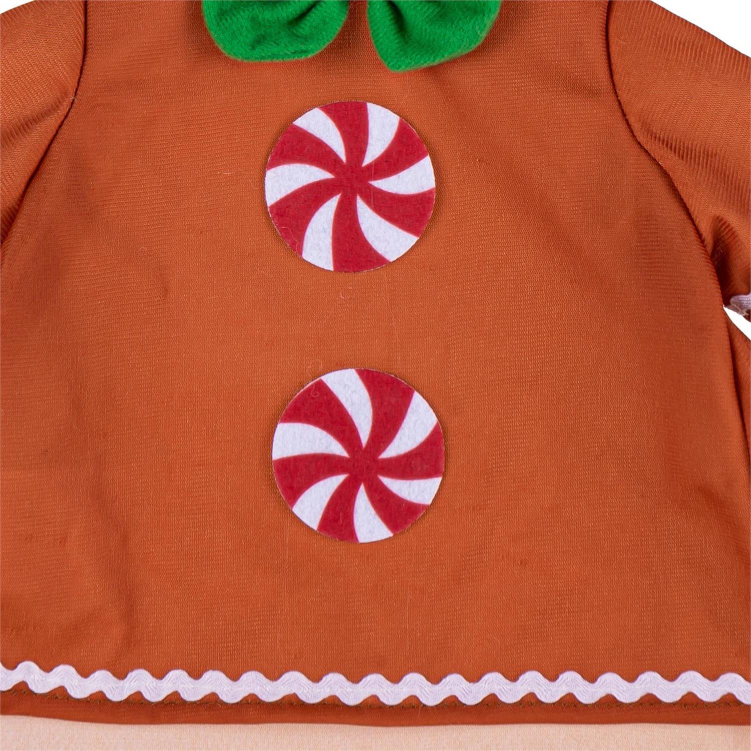 Close-up of an orange-brown garment or costume panel with two red-and-white swirl candy graphics and a white scalloped trim along the bottom edge.
