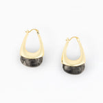 A pair of gold huggie hoop earrings with a dark gray and black marbled stone drop, shown on a clean white background.