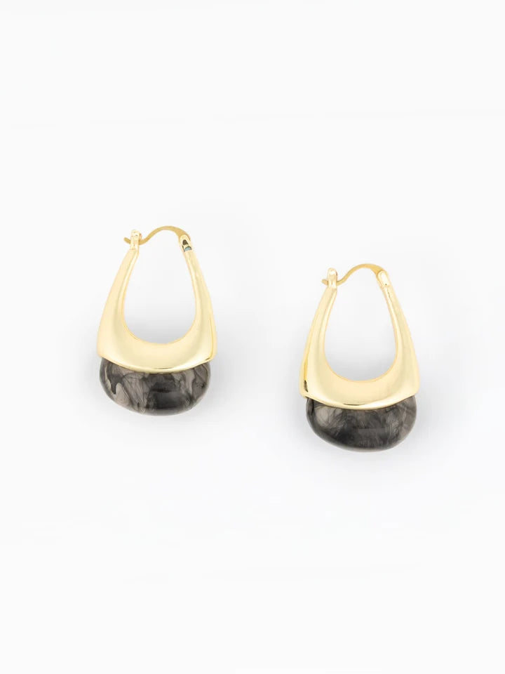 A pair of gold huggie hoop earrings with a dark gray and black marbled stone drop, shown on a clean white background.