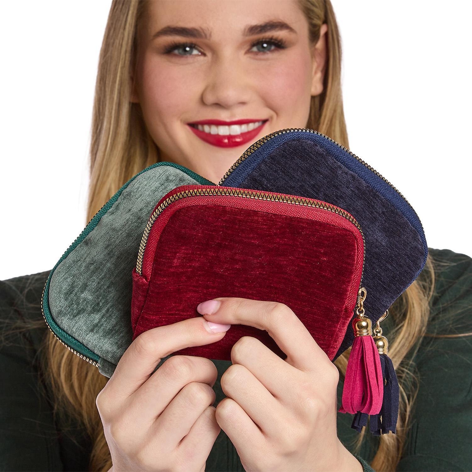 Woman holding three colorful zippered pouches with tassels.