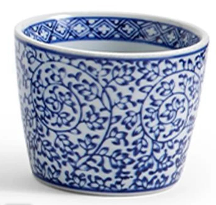 A small white ceramic cup or planter decorated with a classic blue floral and vine pattern, shown against a plain white background.