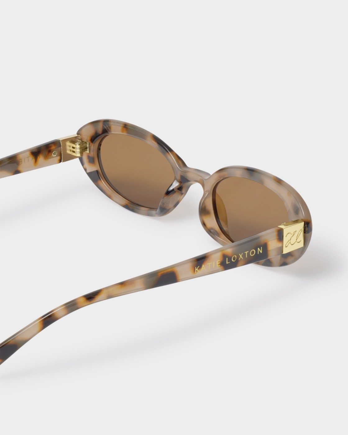 Sunglasses with tortoiseshell frame and brown lenses on a white background