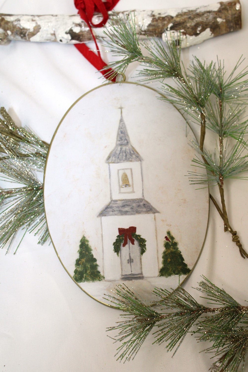 Tawnya Norton Christmas Church double-sided oval metal ornament featuring a festive church scene, designed for Christmas trees, ornament stands, and holiday displays.