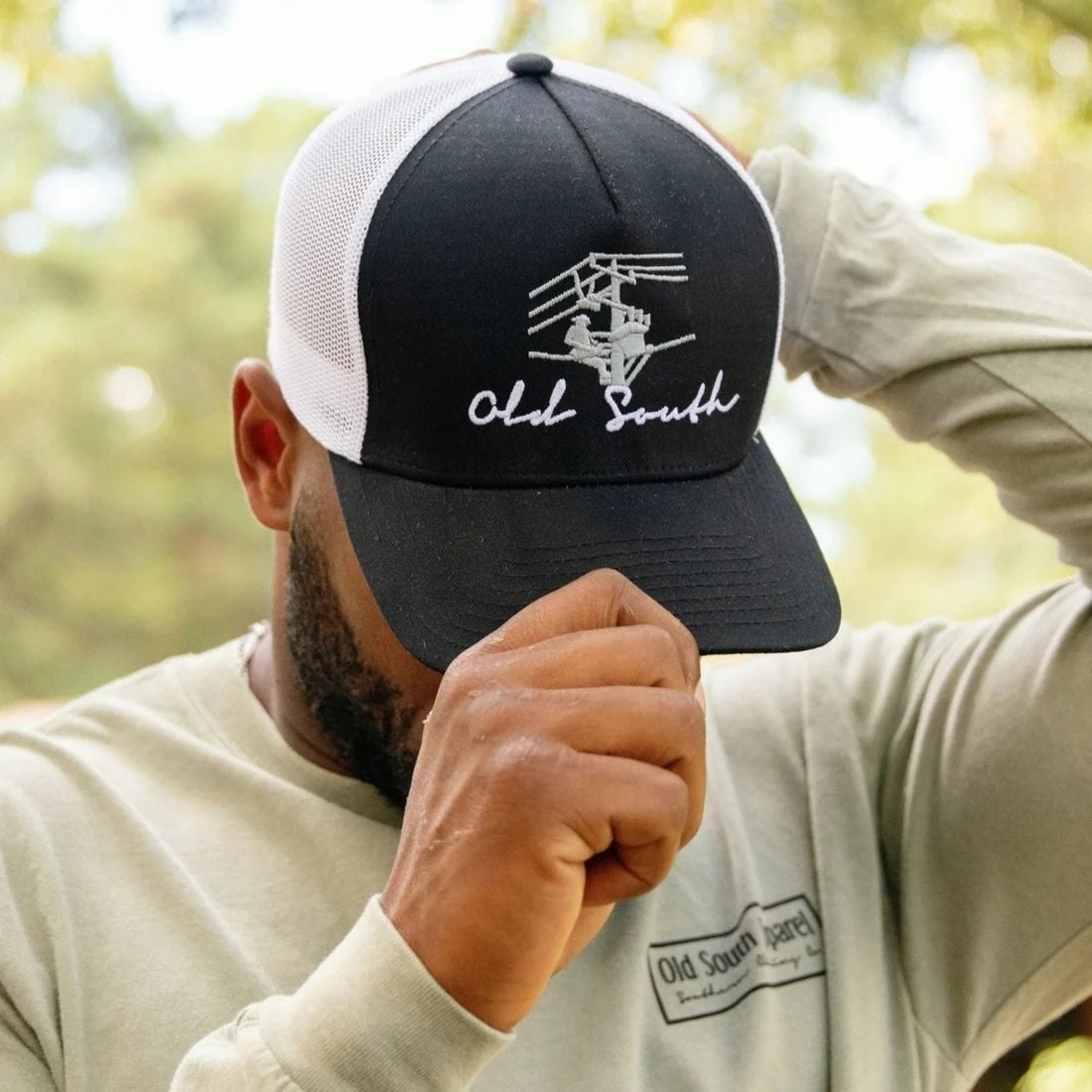 Old South Apparel Lineman Trucker Hat in Black and White featuring a structured crown, pre-curved visor, Lineman design, and adjustable snap-back closure.
