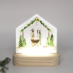 Haley Bush Evergreen Nativity LED tabletop featuring an illuminated Christmas Nativity scene with evergreen-inspired artwork on a freestanding acrylic display.
