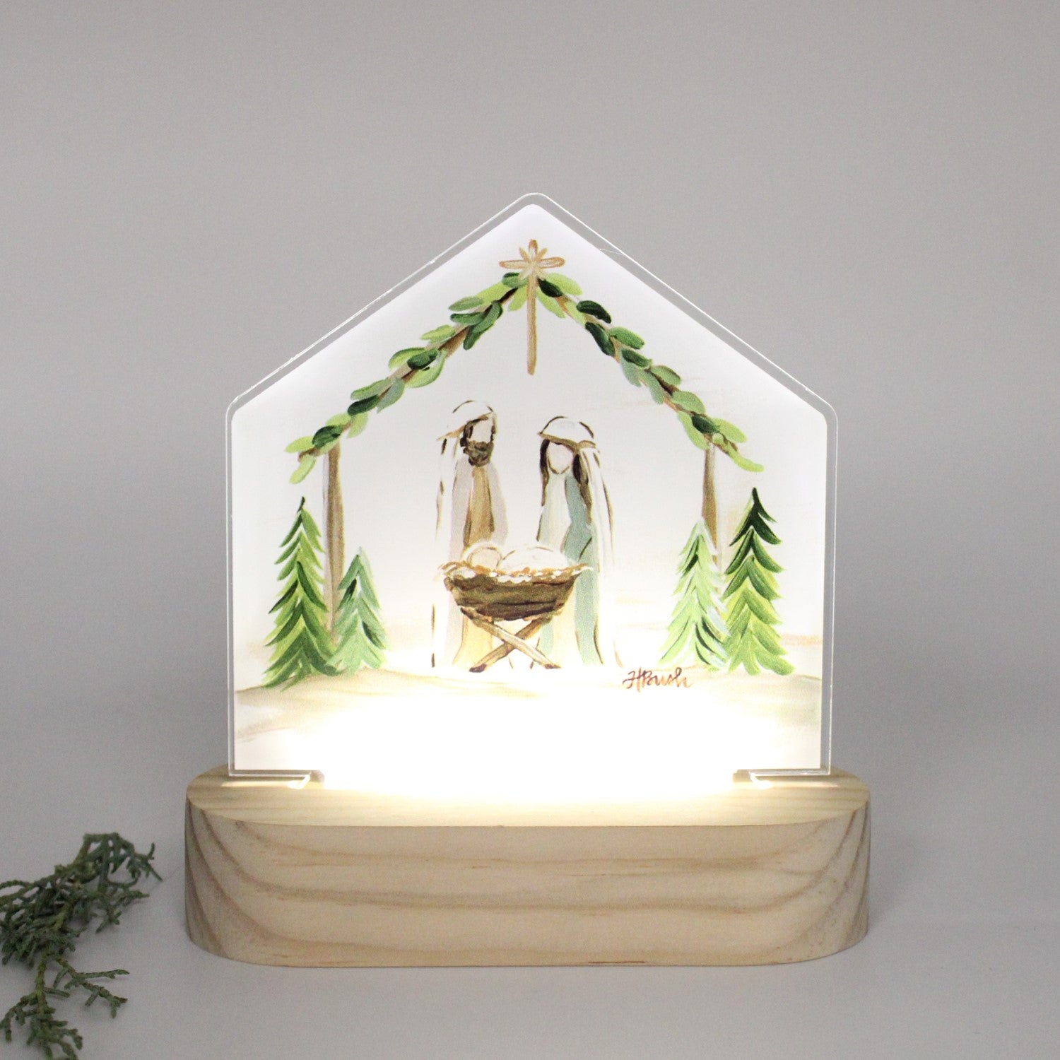 Haley Bush Evergreen Nativity LED tabletop featuring an illuminated Christmas Nativity scene with evergreen-inspired artwork on a freestanding acrylic display.